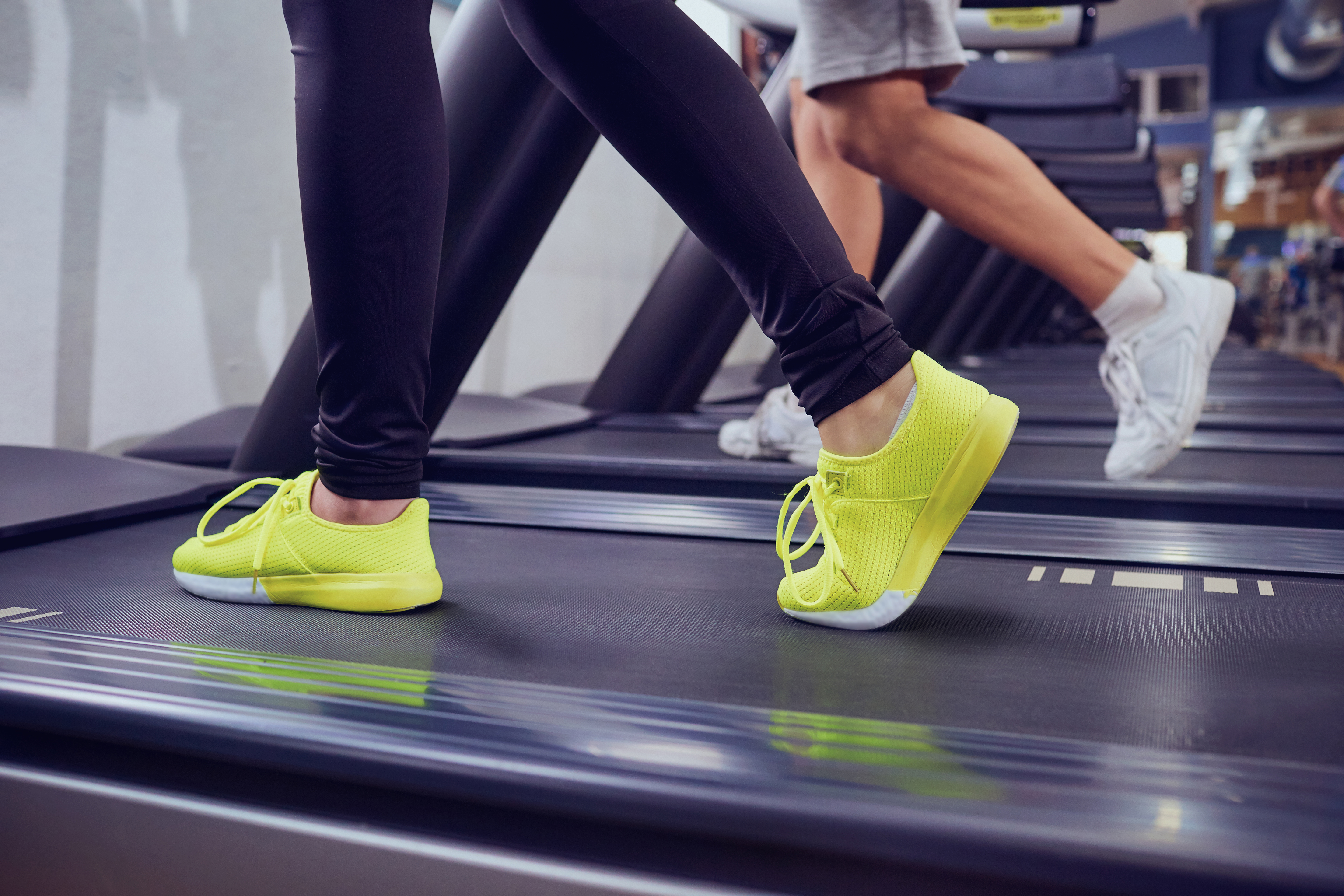 Detail of female legs on a treadmill in the gym